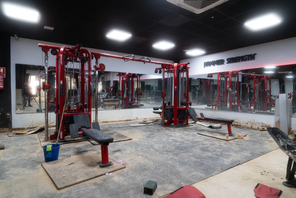 Miembros de la comunidad y del equipo de Titán Fitness trabajando juntos en la reforma del gimnasio.