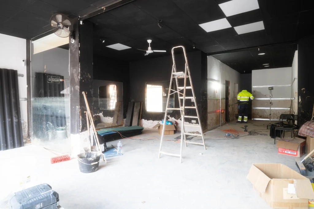 Vista amplia del interior del gimnasio Titán Fitness casi finalizado, con equipos y espacios mejorados.